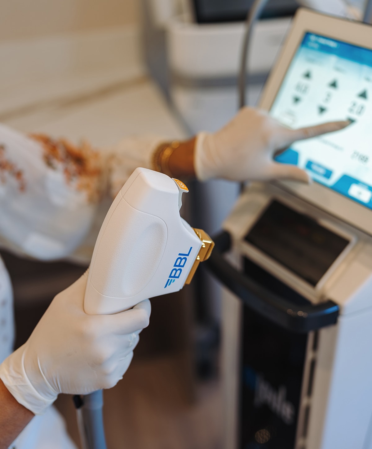 Hand holding a BBL device in clinic setting.