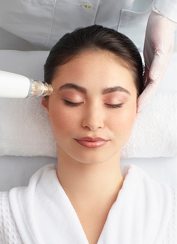 Woman receiving a facial treatment in spa setting.