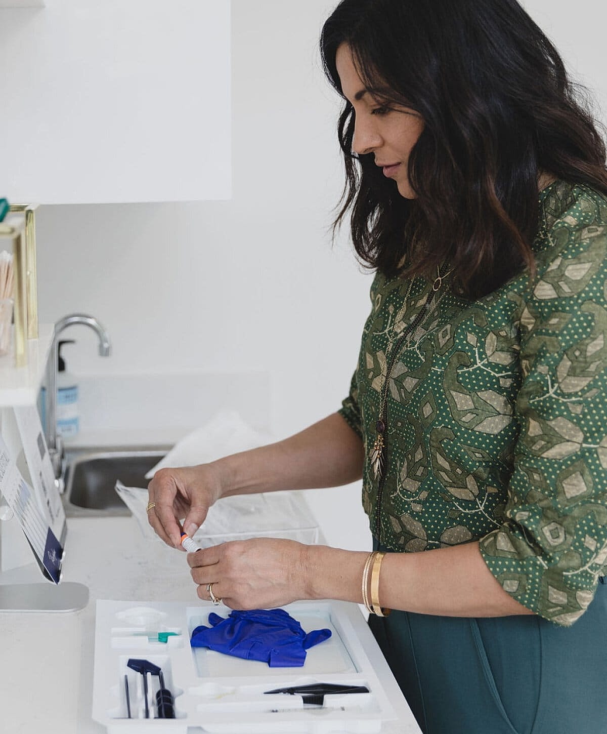 Woman preparing medical supplies in a clinic.