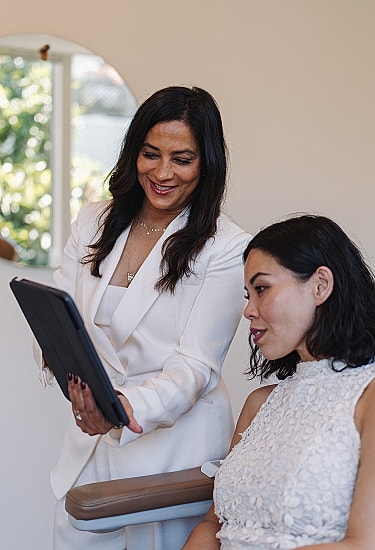 Consultation between two women in a bright room.