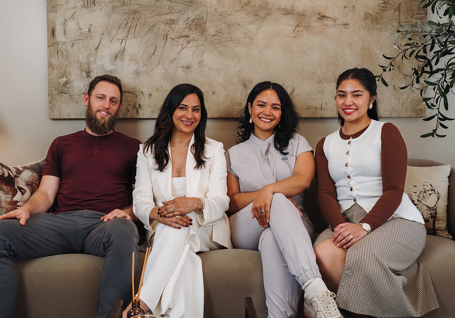 Group photo of four smiling adults sitting together.