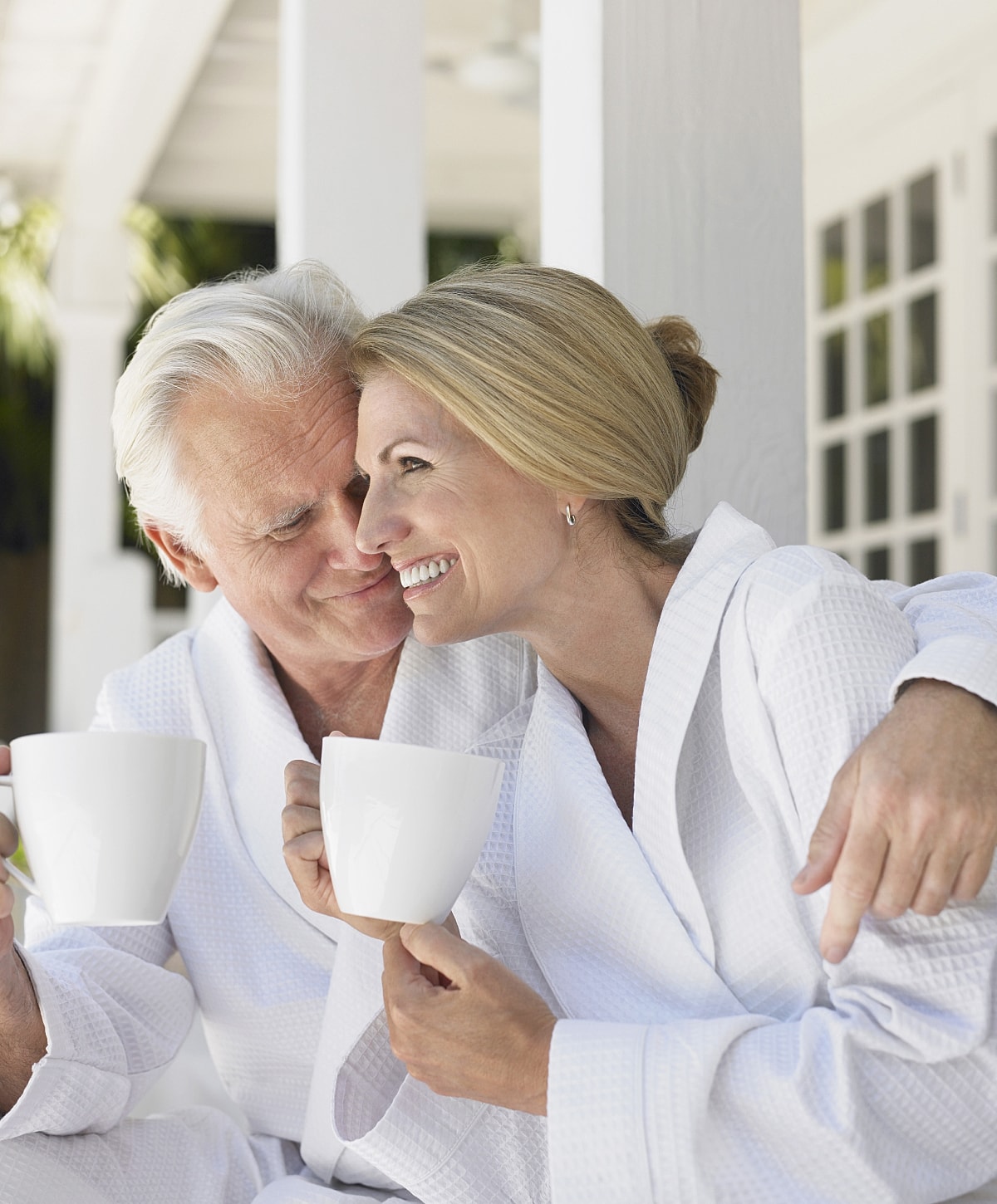 Couple enjoying coffee in matching robes.