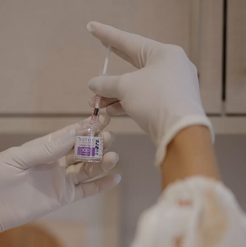 Administering a cosmetic injection from a vial.