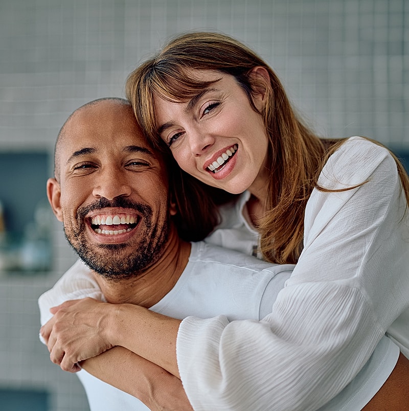 Happy couple smiling together in close embrace.