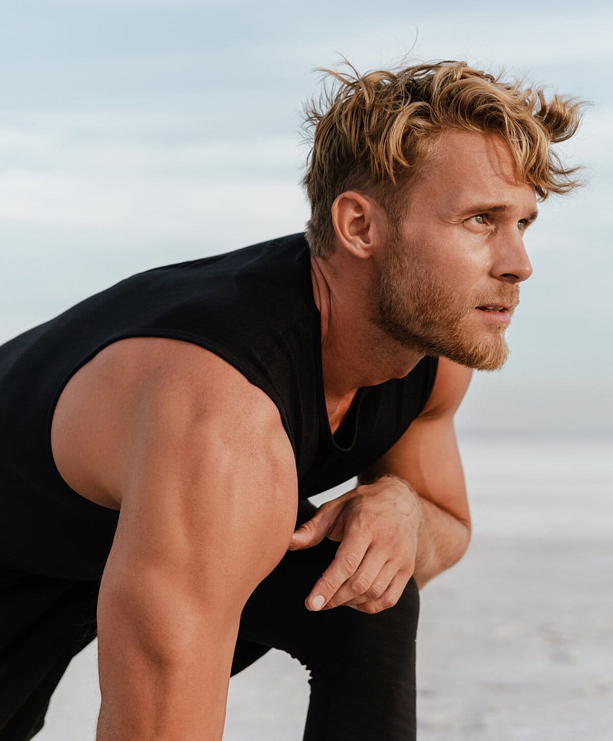 Man preparing for exercise outdoors at sunset.