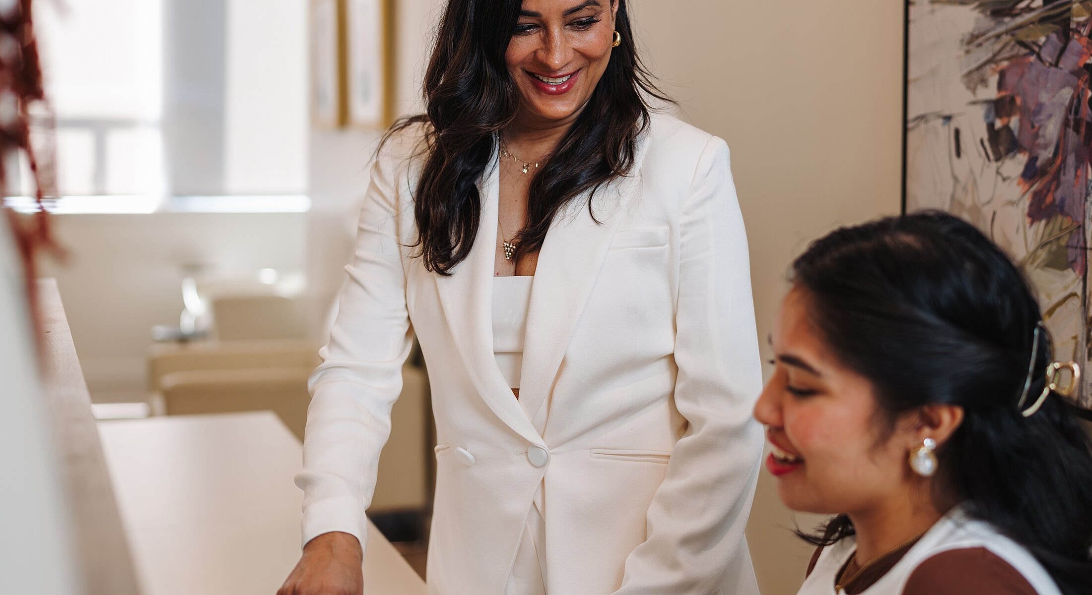 Two women discussing in a bright office space.