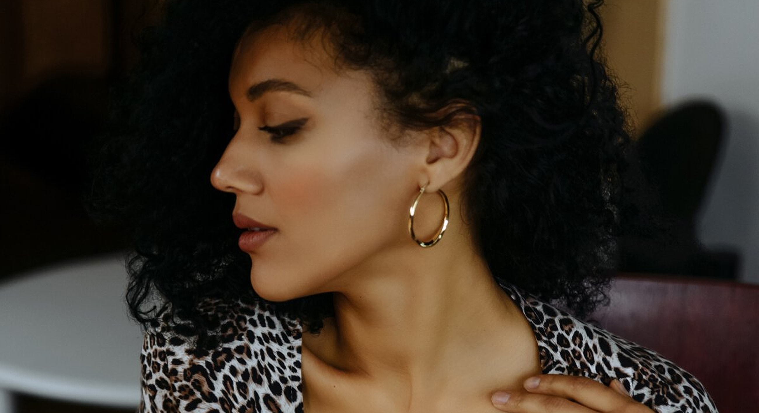 Woman with curly hair and hoop earrings.